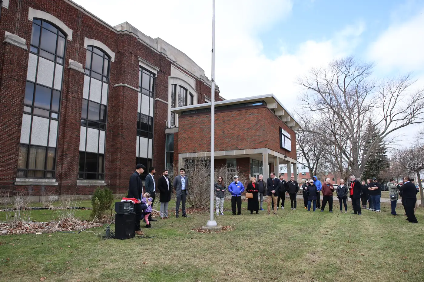 Community gathered on the grounds of the historic SCITS building, marking the school's founding lineage